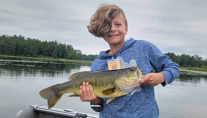 Happy kid with large bass fish